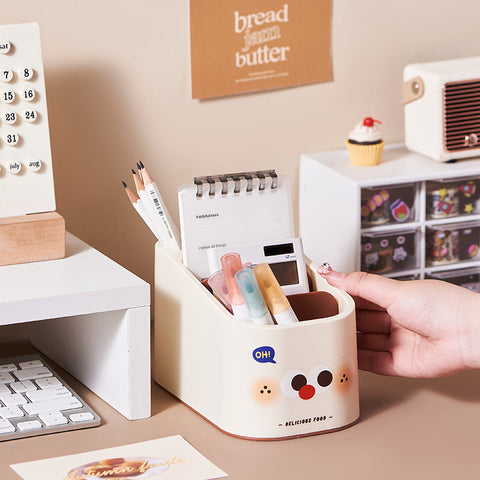 Desk organizer with stationery items on a desk, featuring a hand reaching in.