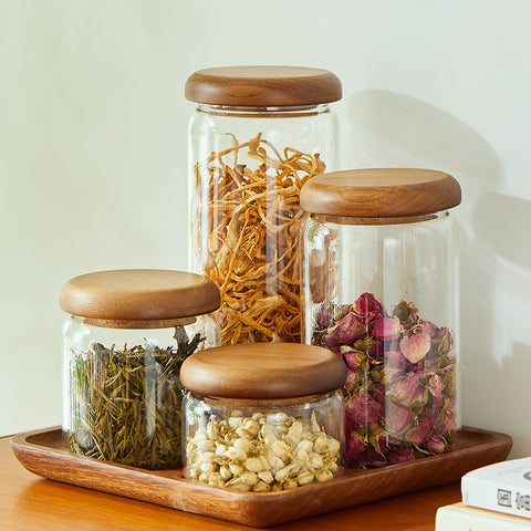 Acacia glass kitchen storage jar set with wood lids displayed on a tray