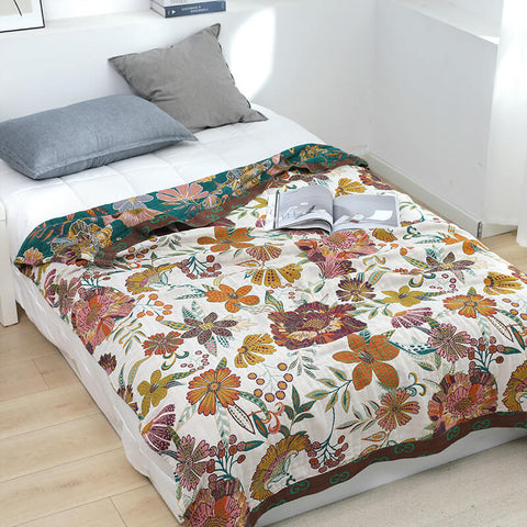 Beige floral throw blanket styled on a twin bed with neutral pillows.