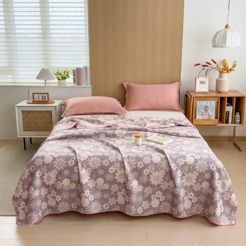 Blush Bloom reversible summer blanket spread across bed in softly lit bedroom with pink pillows