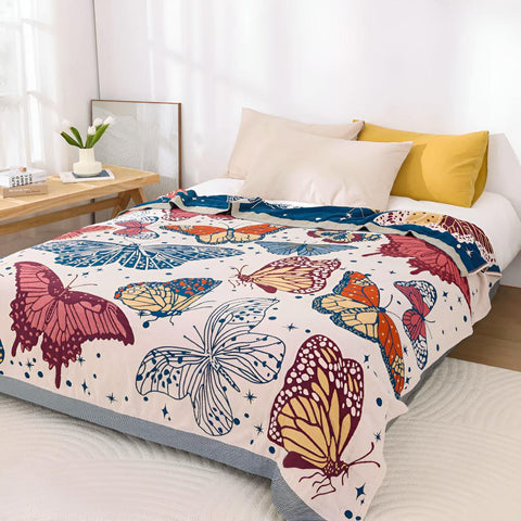 Colorful butterfly cotton throw blanket on bed, perfect as a lightweight summer blanket or decorative layer.
