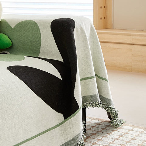 Close-up of sofa arm and fringe of Emerald Green Clover floral chenille slipcover