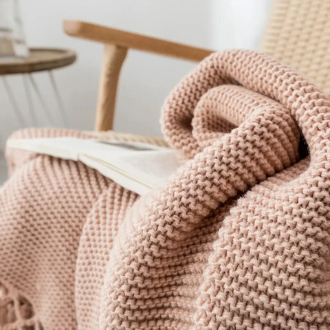 Close-up of Dusty Rose Nordic Knit Blanket with chunky texture and long tassels