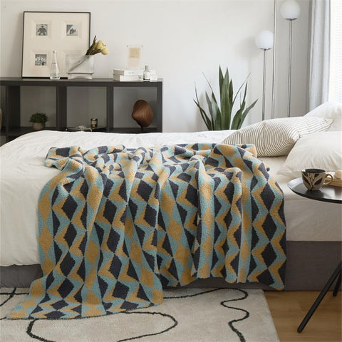 Geometric knit velvet throw blanket draped across bed – cozy modern bedroom décor