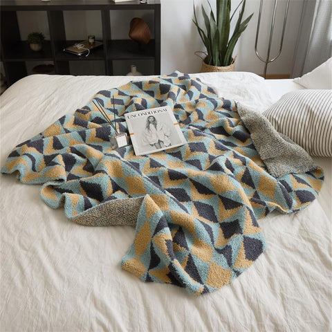 Geometric velvet knit throw blanket on white bed – modern sofa and bed décor