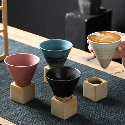 Hand picking up Kyoto espresso cup from ceramic cup collection on table