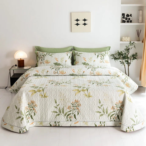 Botanical quilted cotton bedding set styled on bed with green pillows and nightstand