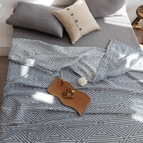 Blue cotton towel blanket set on bed with neutral decor