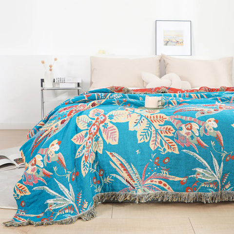 Tropical floral cotton blanket reversible throw styled on a bed with turquoise and red design