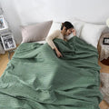 Woman relaxing with pink waffle cotton summer blanket on bed