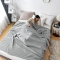 Woman relaxing with pink waffle cotton summer blanket on bed