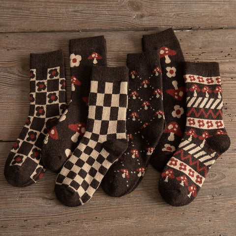 A collection of Yuki Retro Wool Socks with various patterns including checkered and floral, displayed on a wooden surface.