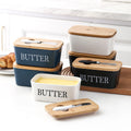 Set of butter dishes with wooden lids and handles on a kitchen counter.