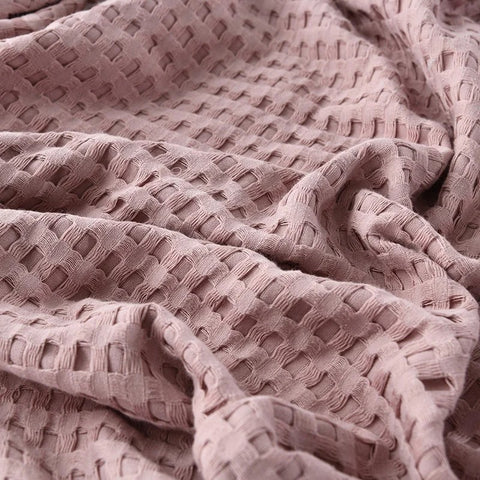 Lightweight pink summer blanket in minimalist bedroom