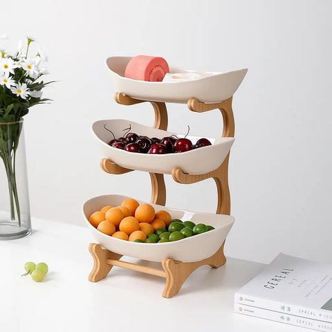 3-tier white ceramic bamboo fruit basket with pears, grapes, and cherries in minimalist modern kitchen
