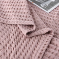 Woman relaxing with pink waffle cotton summer blanket on bed