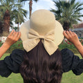 Woman wearing khaki straw sun hat with bow detail