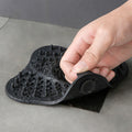 Close-up of black silicone drain cover being peeled for cleaning