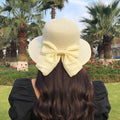 Lightweight straw hat with large bow in milky white color
