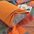 Colorful quilt with a cup and saucer on a patterned fabric background