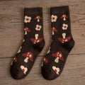 A pair of Yuki Retro Wool Socks with a geometric pattern in brown, red, and beige colors, displayed on a wooden surface.