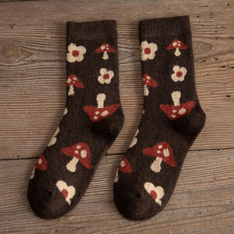 A pair of Yuki Retro Wool Socks with a geometric pattern in brown, red, and beige colors, displayed on a wooden surface.