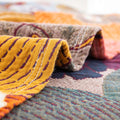 Close-up texture and stitching detail of Persimmon Bloom cotton blanket fabric