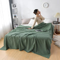 Woman relaxing with pink waffle cotton summer blanket on bed
