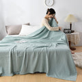 Woman relaxing with pink waffle cotton summer blanket on bed