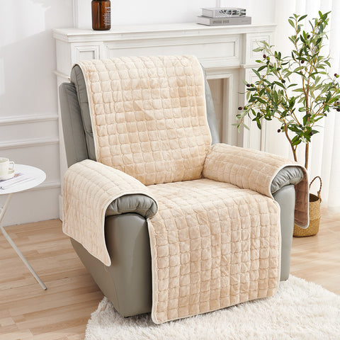Beige quilted chair cover on a gray armchair in a living room setting.