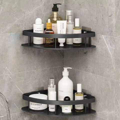Black corner shower caddy with various bottles on a tiled bathroom wall.