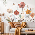 Living room with floral wall decals, a gray sofa, and decorative pillows.