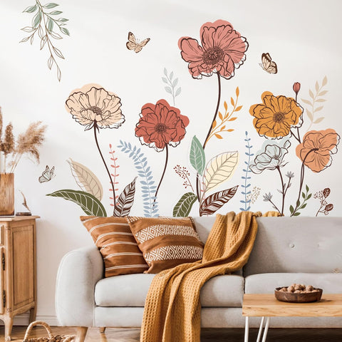 Living room with floral wall decals, a gray sofa, and decorative pillows.