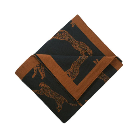 Folded throw blanket with brown and black pattern on a white background