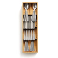 Close-up of stainless steel fork resting in bamboo angled slot

