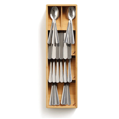 Close-up of stainless steel fork resting in bamboo angled slot

