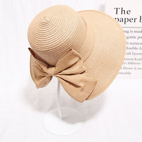Woman wearing khaki straw sun hat with bow detail