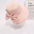 Pink straw sun hat with wide brim, worn outdoors