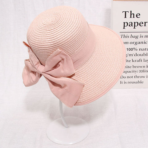 Pink straw sun hat with wide brim, worn outdoors