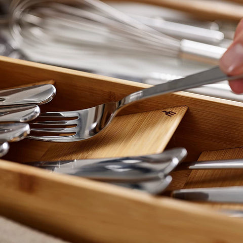 Top-down view of a bamboo flatware organizer filled with utensils

