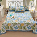 Floral patterned bedspread on a bed with pillows in a bright room.