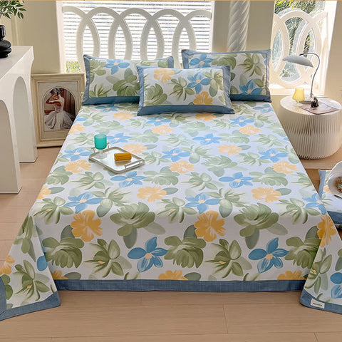 Floral patterned bedspread on a bed with pillows in a bright room.