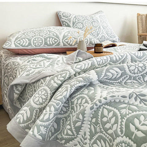 Blue gray geometric leaf quilt bedding set in modern bedroom with minimalist decor
