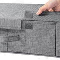 Gray fabric storage box with a hand lifting the lid