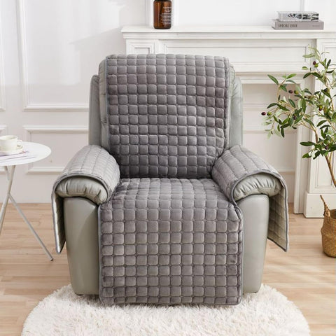 Gray quilted chair cover on a recliner chair in a living room setting.