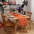 Dining table set for Halloween with pumpkins, bottles, and decorative items.