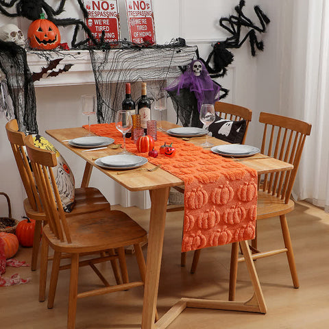 Dining table set for Halloween with pumpkins, bottles, and decorative items.