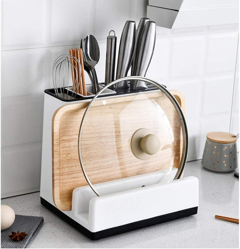 Kitchen utensil holder with cutting board, ladles, and other tools on a kitchen counter.