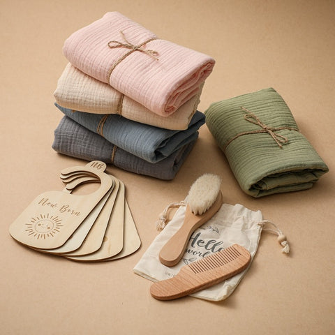 Stack of folded baby blankets with wooden tags, brush, and comb on a beige background