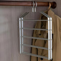 Metal hanging rack on a wooden rod with a beige coat in the background